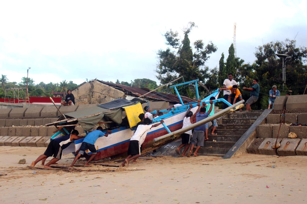Masyarakat pesisir memindahkan perahu dari laut ke darat dengan bergotong royong di pesisir Kelurahan Nunbaun Sabu, Kota Kupang/Mariano Ledjap 